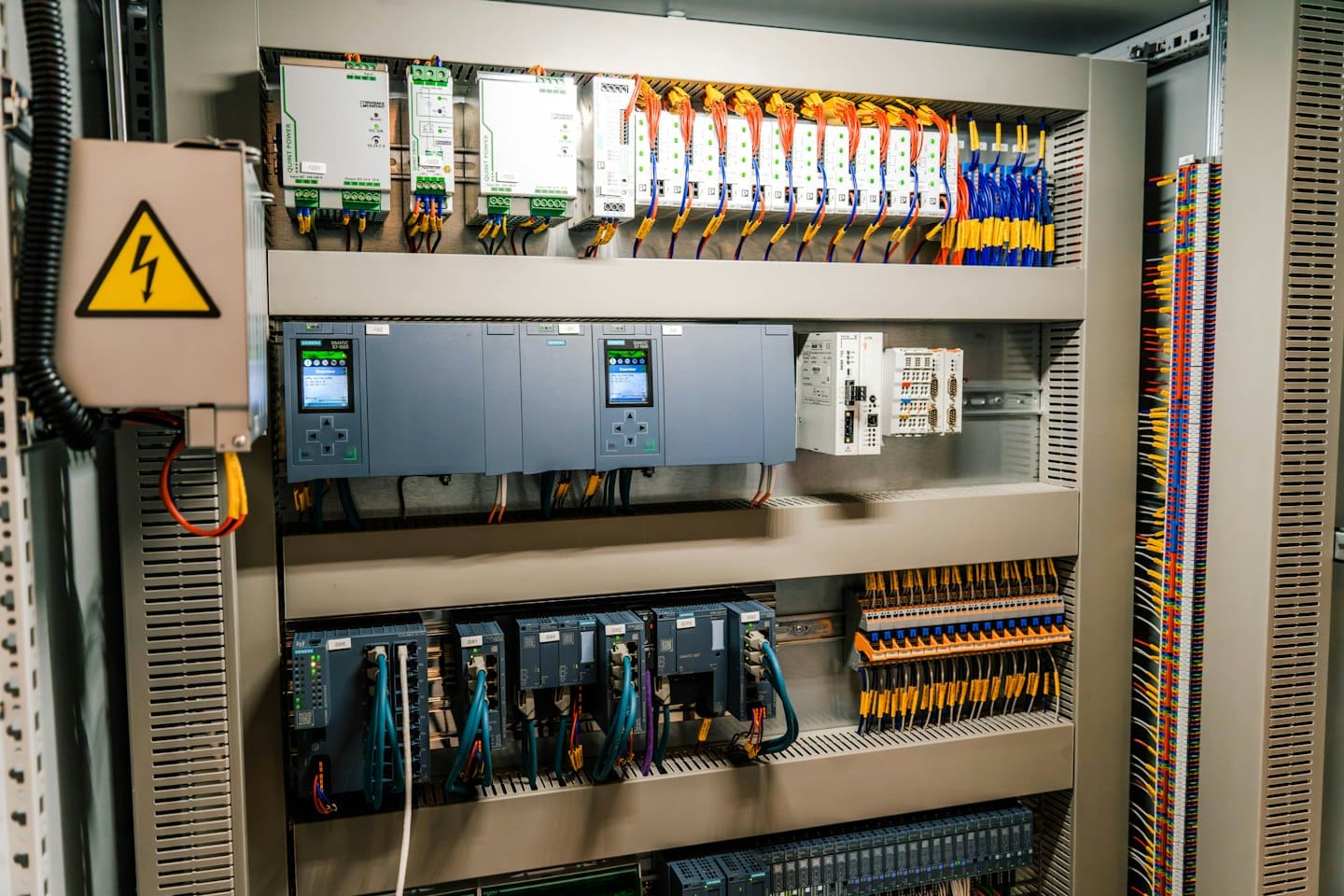 Karmaşık kablolar ve bileşenlerle dolu açık elektrik kumanda panosu.